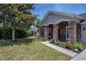 Charming home featuring stone accents, a well-manicured lawn, and beautiful landscaping at 31920 Parkdale Dr, Leesburg, FL 34748