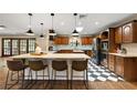 Spacious kitchen features wood cabinets, granite counters, a large island, and checkerboard floors at 32132 Hickory Ln, Sorrento, FL 32776