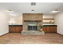 Cozy living room with a brick fireplace, built-in cabinets, and wood floors at 32132 Hickory Ln, Sorrento, FL 32776