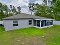 The rear view of this home showcases an enclosed lanai with a well-maintained lawn and landscaping at 3638 Sw 127Th Lane Rd, Ocala, FL 34473