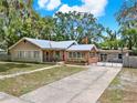 Inviting single-story home featuring a brick facade, gated driveway, and ample parking space at 506 Perkins St, Leesburg, FL 34748