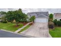 Exterior view of a well-maintained home, showcasing the driveway, landscaping, and architectural details at 506 Weston Manor Dr, The Villages, FL 32162