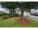 Well-maintained front yard with lush green grass, mature trees, and beautiful landscaping at 506 Weston Manor Dr, The Villages, FL 32162