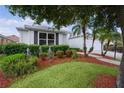 Well-maintained front yard with lush green grass, mature trees, and beautiful landscaping at 506 Weston Manor Dr, The Villages, FL 32162