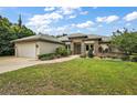 Charming single-story home boasts stone detailing, a two-car garage, and a well-maintained lawn with mature landscaping at 562 Dowling Cir, Lady Lake, FL 32159