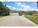 Attractive single-story home featuring stone accents, a two-car garage, and a well-kept front lawn at 562 Dowling Cir, Lady Lake, FL 32159