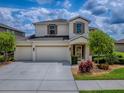Charming two-story home featuring a three-car garage, well-manicured lawn, and tasteful landscaping at 718 Lake Douglas Dr, Groveland, FL 34736