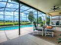 Relaxing screened-in lanai featuring a private pool and comfortable seating area overlooking the lush backyard at 718 Lake Douglas Dr, Groveland, FL 34736