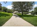 A long driveway leads to a home with mature trees that dot the large manicured yard at 7249 Chesterhill Cir, Mount Dora, FL 32757