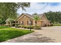 Well-maintained home exterior with lush landscaping, a spacious driveway, and a two-car attached garage at 7685 Lake Angelina Dr, Mount Dora, FL 32757