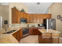 Bright kitchen featuring tile backsplash, stainless steel appliances, a large island and wood cabinetry at 7685 Lake Angelina Dr, Mount Dora, FL 32757