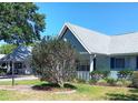 Well-maintained home showcasing a beautifully landscaped front yard and a charming covered porch at 8431 Sw 93Rd Pl # F, Ocala, FL 34481