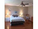 Bright bedroom featuring a queen bed, two nightstands with lamps, ceiling fan, and hardwood floors at 8431 Sw 93Rd Place # F, Ocala, FL 34481