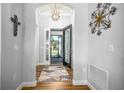 Welcoming foyer with wood floors, decorative lighting, and elegant front door at 8492 Hartford Way, Mount Dora, FL 32757