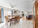 Open concept living and dining area with tile and wood flooring, ceiling fans, and sliding glass doors to the patio at 919 Medira Dr, The Villages, FL 32159