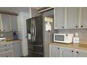 Well-equipped kitchen with stainless steel refrigerator, built-in microwave, and ample cabinet space at 1014 Dustin Dr, Lady Lake, FL 32159