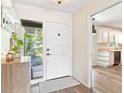 Bright foyer featuring a front door, cabinet, and glimpses of the kitchen at 1016 Cottonwood St, Leesburg, FL 34748