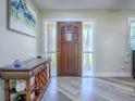 Inviting foyer with wood-look floors, decorative table, and sidelights flanking the front door at 111 Cardinal Ln, Eustis, FL 32726