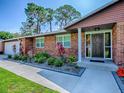 Close-up of a well-maintained brick house with manicured landscaping and a charming front entrance at 111 Cardinal Ln, Eustis, FL 32726