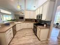 Bright kitchen featuring white cabinetry, stainless steel appliances, and wood-look flooring at 11301 Via Mari Cae Ct, Clermont, FL 34711