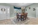 Elegant dining room featuring a chandelier, a large window, and a classic dining set with seating for six at 1350 Mosswood Dr, Leesburg, FL 34748