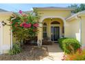 Inviting front porch with seating area and blooming bougainvillea, creating a welcoming entrance at 1446 Arbor Trl, The Villages, FL 32162