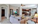 Open-concept living area with tile floors, seamlessly connecting the living room, dining area, and kitchen at 15322 Veramonte Way, Orlando, FL 32828