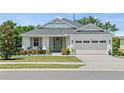 Charming single-story home featuring a well-manicured lawn, lovely landscaping, and a two-car garage at 16211 Oak Breeze Ct, Clermont, FL 34711