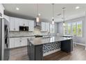 Modern kitchen featuring stainless steel appliances, granite countertops, a large island, and white cabinetry at 16211 Oak Breeze Ct, Clermont, FL 34711