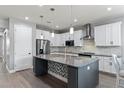 Modern kitchen featuring stainless steel appliances, granite countertops, a large island, and white cabinetry at 16211 Oak Breeze Ct, Clermont, FL 34711
