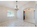 Bright dining room with tiled floors, a decorative chandelier, and a view into the entryway through an arched doorway at 1663 Markel Dr. Dr, Winter Garden, FL 34787