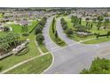 Scenic aerial view of a community entrance with lush landscaping and well-maintained streets at 169 Jensen Dr, Groveland, FL 34736