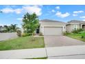 Inviting single-Gathering home featuring a well-manicured lawn and brick paver driveway at 169 Jensen Dr, Groveland, FL 34736