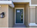 Inviting front entrance features a stylish teal-colored door with sidelight, and a modern lantern at 2675 Ridgetop Ln, Clermont, FL 34711