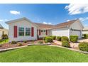 Well-maintained home with green lawn, red shutters, and neat landscaping for great curb appeal at 3041 Batally Ct, The Villages, FL 32162