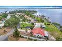 A lakefront view features a tile roof home with palm trees and a private dock at 33620 Picciola Dr, Fruitland Park, FL 34731