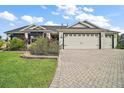 Charming front exterior with well-manicured lawn, mature landscaping, and an attached two-car garage at 342 Mccormick Ln, The Villages, FL 32162