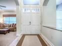 Bright foyer featuring double doors, neutral tones, and a view into the inviting living area at 3775 Brantley Place Cir, Apopka, FL 32703