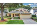 Inviting single-Gathering home featuring manicured landscaping and an attached two-car garage at 3842 Beacon Ridge Way, Clermont, FL 34711