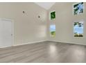 Bright living room with soaring ceilings, large windows, and modern flooring at 3842 Beacon Ridge Way, Clermont, FL 34711