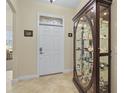 View of the entryway with decorative door and display cabinet on tile floor at 3948 Serena Ln, Clermont, FL 34711
