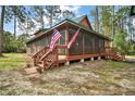 Cozy cabin with a spacious screened-in porch, complete with wooden stairs and decorative lattice at 41513 Aspen St, Eustis, FL 32736