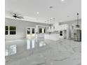Expansive open kitchen and living area featuring sleek marble flooring, modern lighting, and high-end stainless steel appliances at 42191 Cashew St, Eustis, FL 32736
