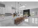 Bright, open kitchen with large island, pendant lighting, and white marble floors at 42191 Cashew St, Eustis, FL 32736