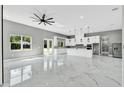 Open-concept living space with a kitchen, gray walls, modern lighting, and marble floors, offering a stylish and spacious design at 42191 Cashew St, Eustis, FL 32736