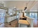 Bright kitchen features white cabinets and appliances, with a view into the living area at 519 Hawthorne Blvd, Leesburg, FL 34748