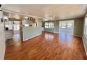 Spacious living area featuring wood flooring, a ceiling fan, and easy access to the kitchen at 519 Hawthorne Blvd, Leesburg, FL 34748