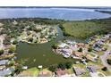 Overhead view of home on a waterfront lot with mature trees and manicured lawn at 5339 Kings Ct, Fruitland Park, FL 34731