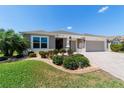Inviting single-story home with lush landscaping and a patterned driveway at 560 Caputo Ct, The Villages, FL 32163