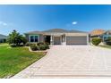 Attractive single-story home featuring a decorative driveway and well-kept lawn at 560 Caputo Ct, The Villages, FL 32163